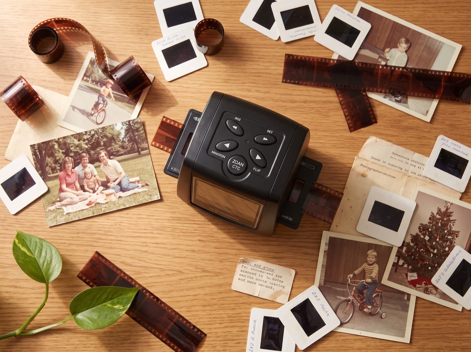 Top-down flat lay of the scanner surrounded by negatives, slides, and vintage family prints